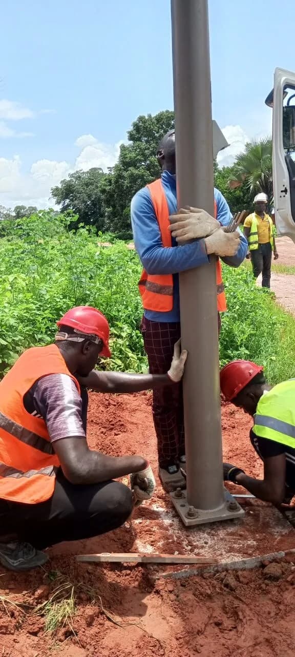 Ancrage du mât d'un lampadaire solaire par l'équipe technique