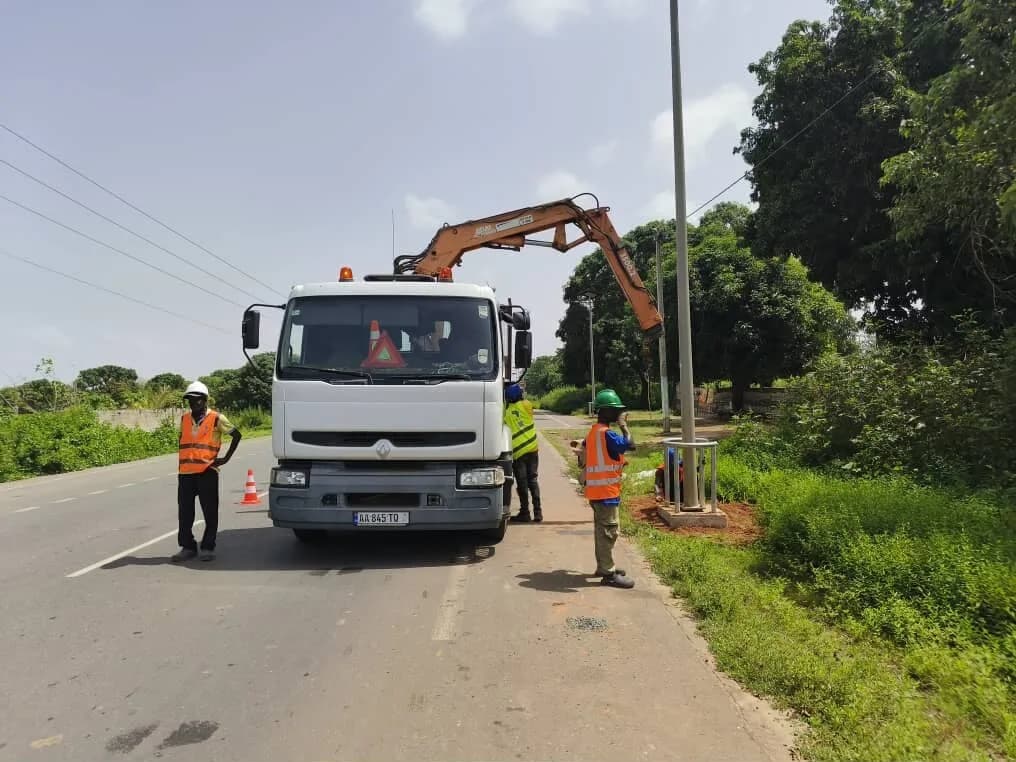 Camion-grue et techniciens lors de l'installation d'un lampadaire solaire à Baconding